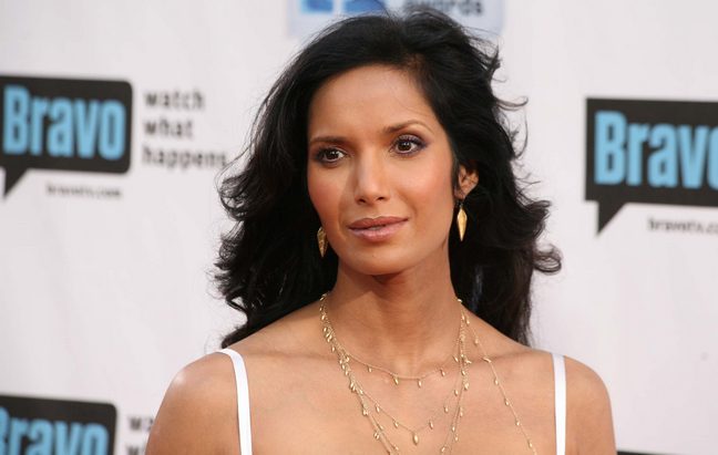 Padma Lakshmi white spaghetti strap dress, gold earrings, gold layered necklace