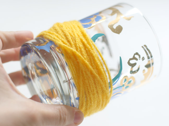 yellow yarn wrapped around a empty mason jar