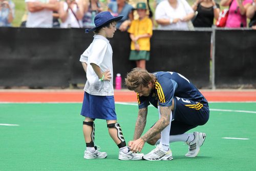 david beckham ties shoes, david beckham blue shorts, blue shirt