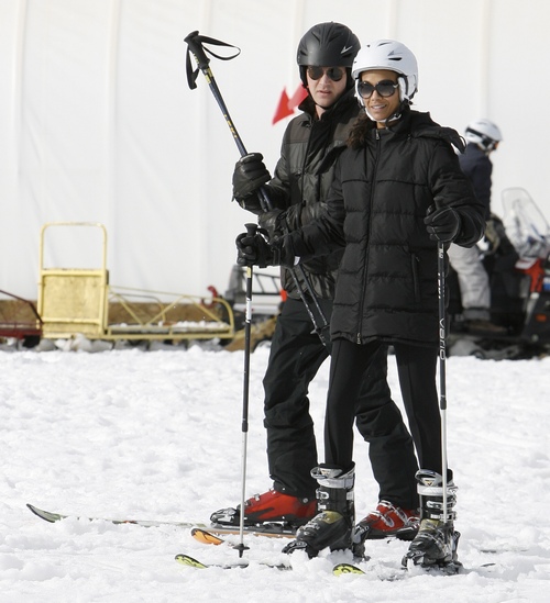 Zoe Saldana, black winter coat, skis, sunglasses