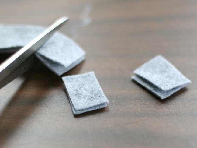 cutting squares of gray felt