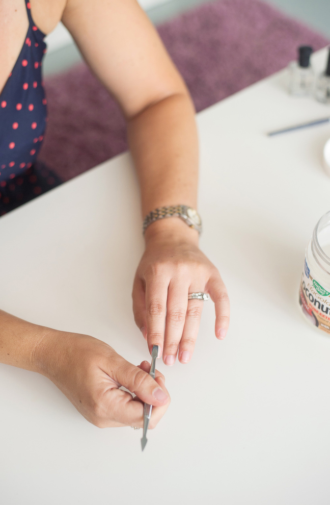 pushing back cuticles with a metal cuticle pusher