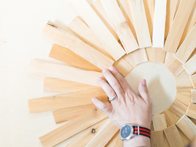 hand-pressing-wood-shims-into-wreath