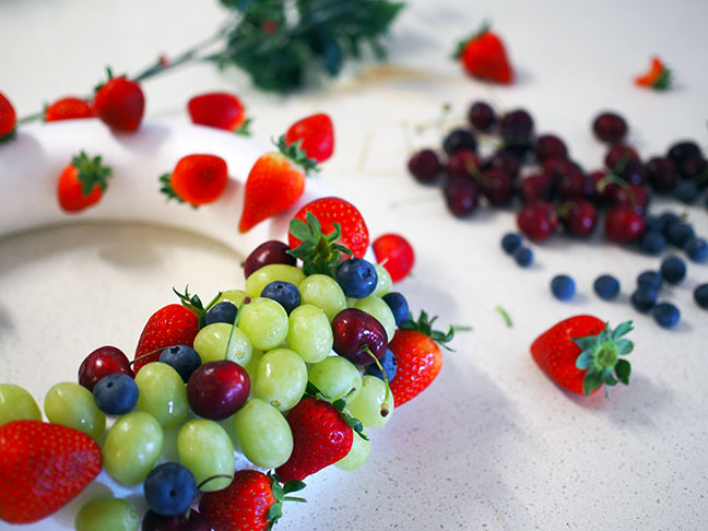 Continue placing fruit into the wreath with toothpicks until filled.