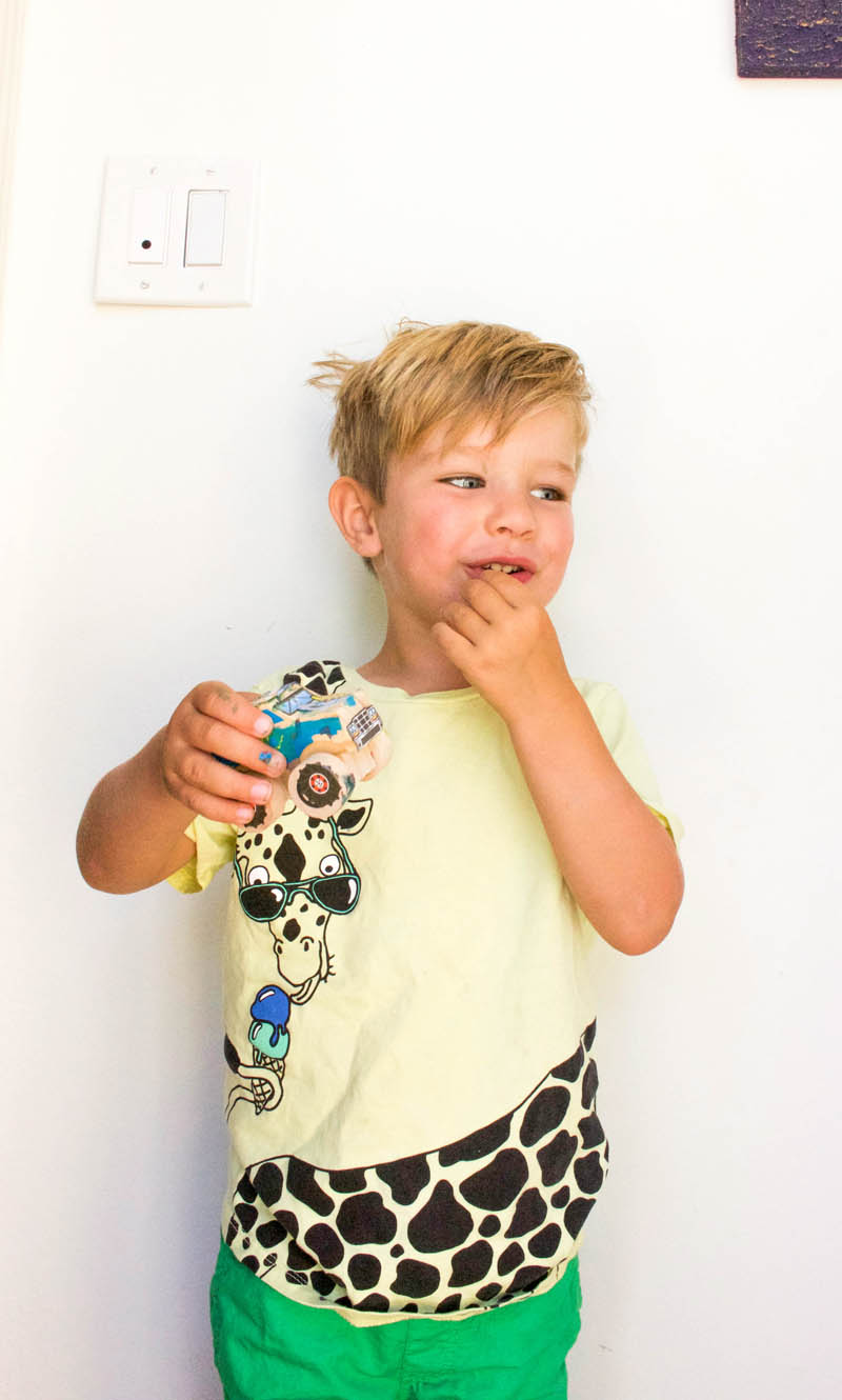 little boy in giraffe shirt with truck