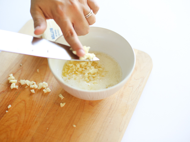 adding garlic to melted butter