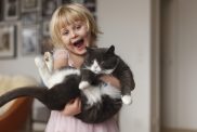 young blonde girl holding cat how to teach children to be gentle with cats