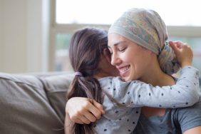 Young mom with cancer hugging daughter post-mastectomy survival guide