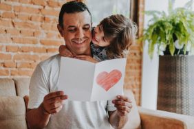 Son handing postcard to father on father's day