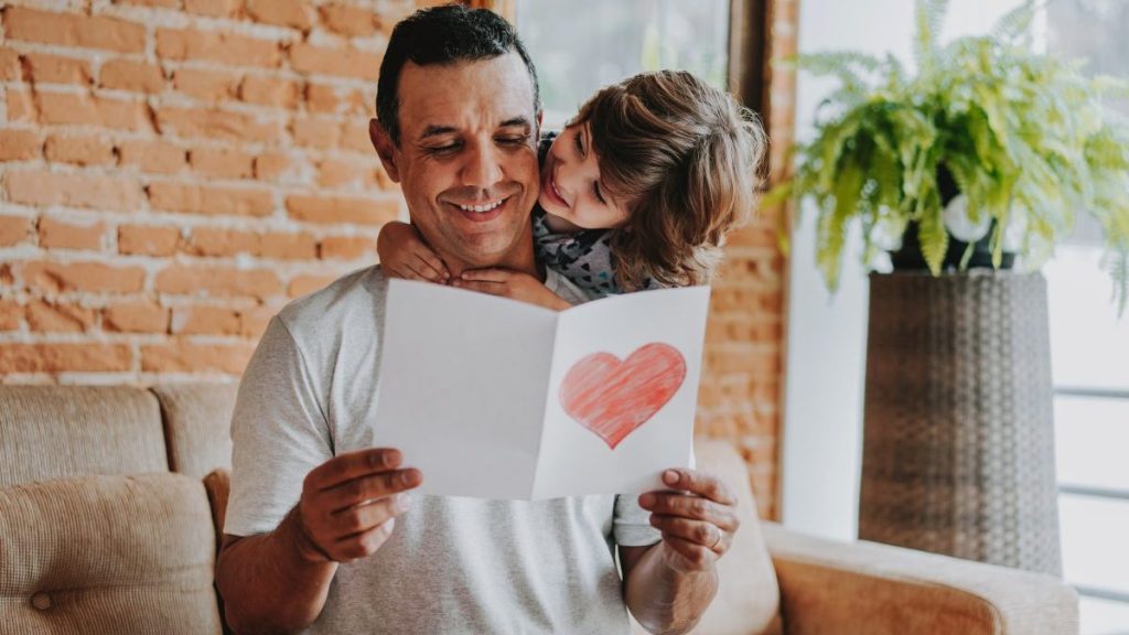 Son handing postcard to father on father's day