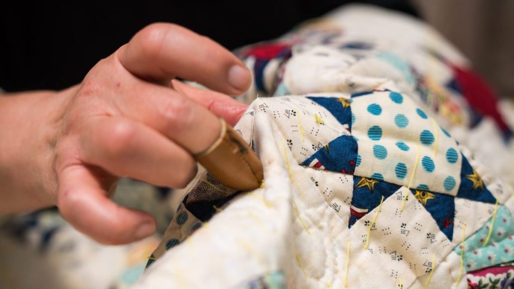 A close-up shot of a senior woman sewing and making crafts in her home