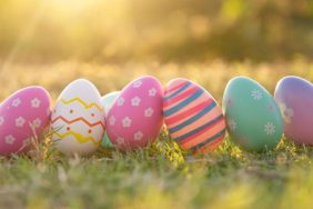 An Easter egg sits in the lawn in the evening golden sun. at Easter