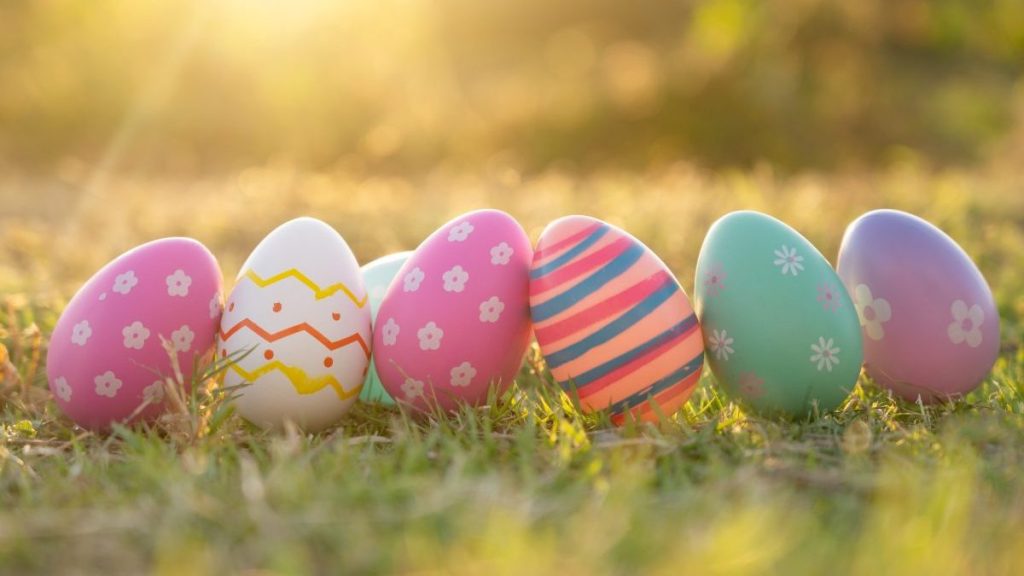 An Easter egg sits in the lawn in the evening golden sun. at Easter