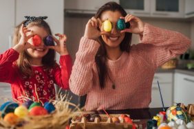 Happy girl having fun with mom and Easter eggs