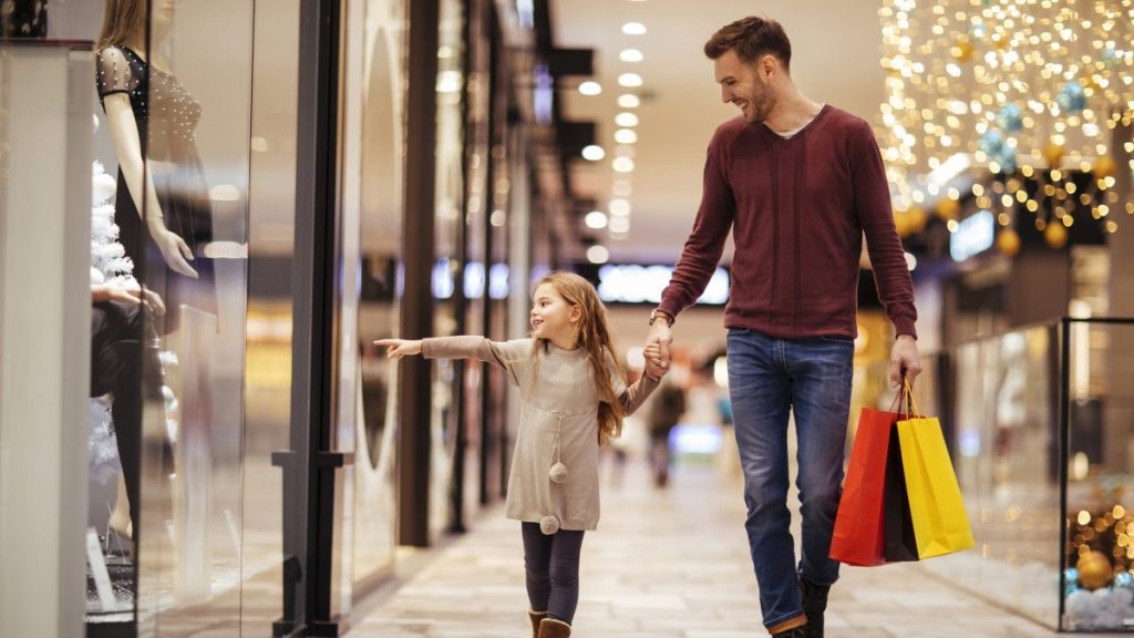 Father and daughter spending a day in shopping mall